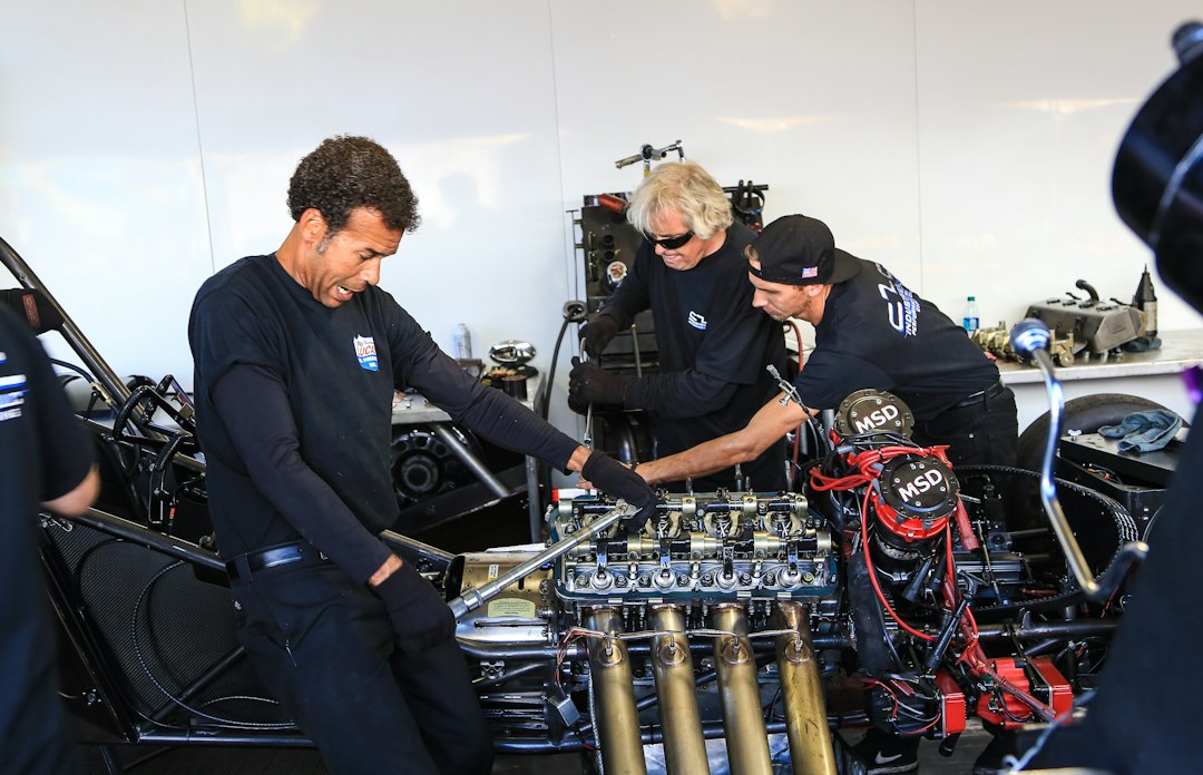 Professional automotive technicians collaborating on a high-performance engine in a workshop