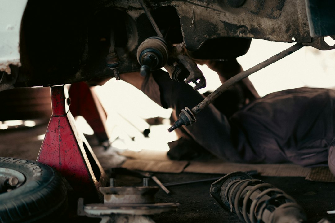 Professional mechanic performing diagnostic work on an exotic sports car in specialized service facility